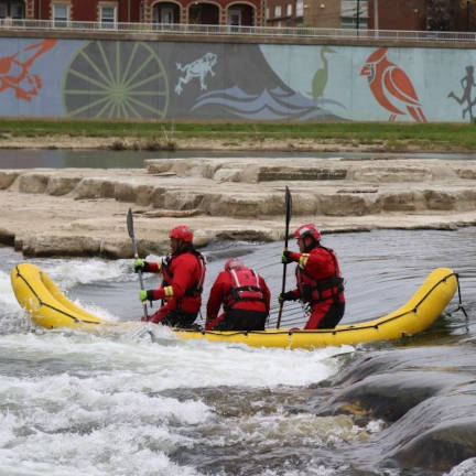 Dayton Firefighter Rescue Swimmers Paddling Boat in Great Miami River Dayton Firefighter Rescue Swimmers paddling an inflatable boat through small rapids in the Great Miami River.