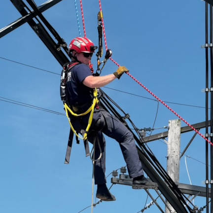 Dayton Firefighter Rescue Technician Suspended by Ropes on Metal Structure Dayton Firefighter Rescue Technician suspended by ropes and using climbing gear on a metal structure high above the ground.