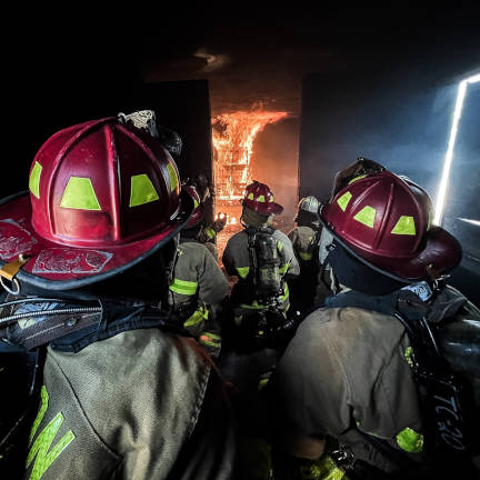 Dayton Firefighters Approaching Burning Room Dayton firefighters approach a burning room from a hallway.